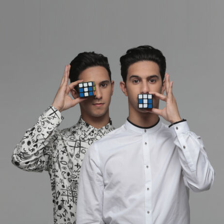 Photo de Tomy et Jordan, les French Twin, tenant chacun un Rubik's Cube avec leurs initales dessus.